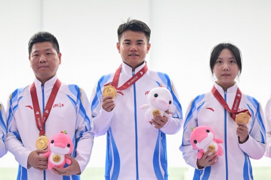10月18日,获得冠军的浙江一队选手王子菲、赵中豪和教练员(从右至左)在颁奖仪式上。新华社记者 丁磊 摄